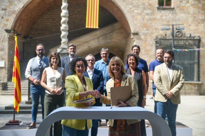La secretària general d'ERC, Marta Rovira, i la viceprimera secretària del PSC, Lluïsa Moret, encaixen mans després de signar l'acord d'investidura davant de la Biblioteca de Catalunya