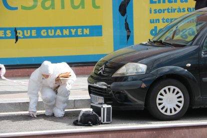 Un agent de la policia científica recollint una mostra després de l’assassinat a Campclar.