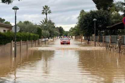 Un vehicle de Bombers avança per un carrer totalment inundat a la Móra.