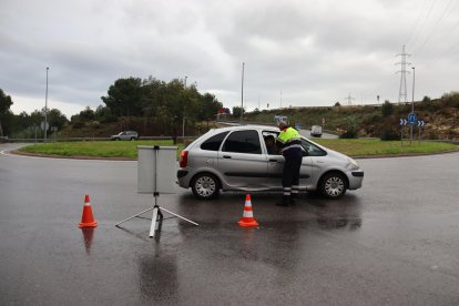Un agent dels Mossos d'Esquadra explicant a un conductor que no pot accedir a l'AP-7 pel risc de pluges intenses.