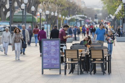 Un cambrer atenent una taula a un restaurant de la Rambla Nova de Tarragona.