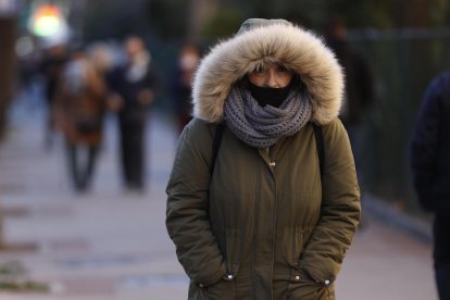 Una mujer pasea por Madrid en una fría mañana.