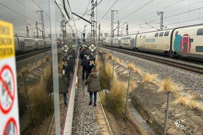 Pasajeros bajante de un tren y caminante por las vías debido a una incidencia en su tren.
