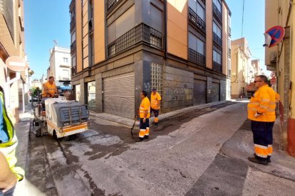 Operaris duent a terme els treballs d'asfaltat d'un carrer de Valls.