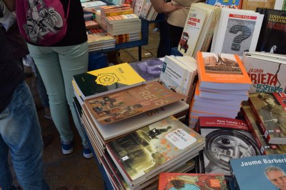 Rosas y libros inundan, un año más, la plaça del Mercadal de Reus. El punto más céntrico de la ciudad y sus alrededores se han llenado de paradas|puestos para ofrecer, a todo el mundo que lo quiera, la posibilidad de comprar el libro deseado y la rosa para|por la pareja, amigos o familiares.