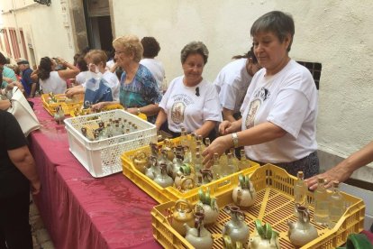 Varias personas participan en la recogida de agua de Sant Magí a pesar de la suspensión de las fiestas a causa de los ataques terroristas a Barcelona y Cambrils.