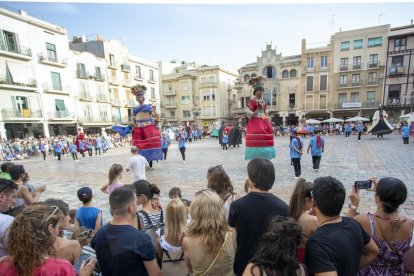 El Corpus en Reus vuelve a la normalidad. En la plaza del Mercadal se van repartirles tradicionales cocas con cerezas.