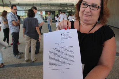 Una membre del comitè d'empresa de Ginsa, Noelia Macías, mostrant la demanda presentada al jutjat social de Reus, durant la protesta convocada davant l'hospital de Reus, el 5 de juliol de 2016