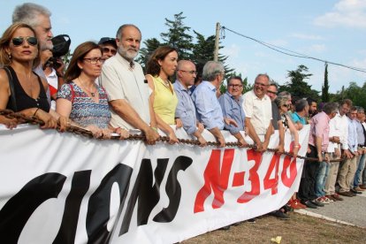 Pla general de diversos alcaldes rere la pancarta i la cadena que reivindica 