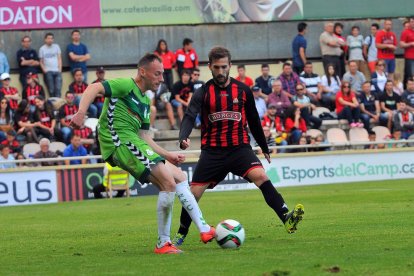 Migue, en un partido contra el Reus, luchando por una pelota con Alberto Benito