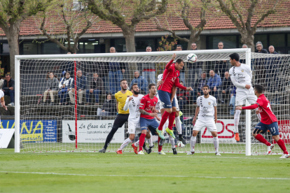 Un jugador de l'Olot prova de rematar un córner davant la porteria custodiada per l'arquer dels pobletans Alberto Varo, ahir.