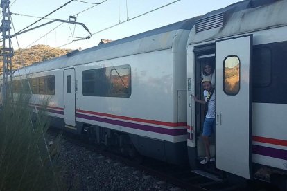 Usuaris d'un tren aturat entre Flix i Móra per una avaria d'electrificació a la línia esperen que els vinguin a rescatar per poder continuar el viatge el 18 de juliol del 2016. Pla general