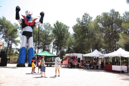 Pla general de l'esplanada de la plaça amb l'estàtua de Mazinger Z mentre diversos seguidors es fan fotos. Imatge del 30 de juliol de 2016