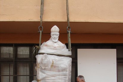 Gallart i un ajudant, col·locant l'escultura al pati de la casa.