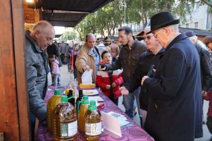 Pla mig d'una parada de la Fira de l'Oli DOP Siurana amb diversos clients tastant oli. Imatge del 3 de desembre de 2017