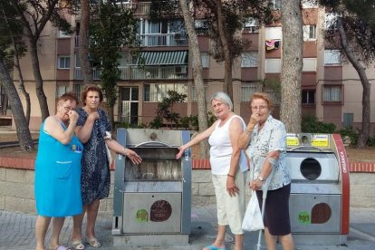 Algunes de les veïnes de la zona, al costat dels contenidors que generen les queixes.