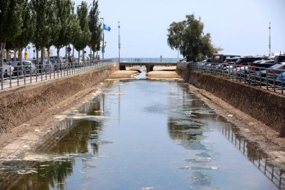 Imatge de la riera de la Móra, plena d'aigua de mar, uns metres abans d'endinsar-se a la sorra de la platja.