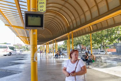 Una passatgera al costat de la pantalla d'informació de la línia Reus-TGN, a l'Estació d'Autobusos.