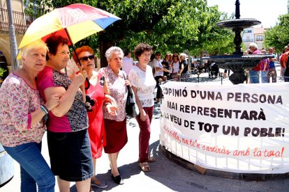 Un grup de dones de Batea davant una pancarta crítica amb la proposta de l'alcalde de marxar a l'Aragó.