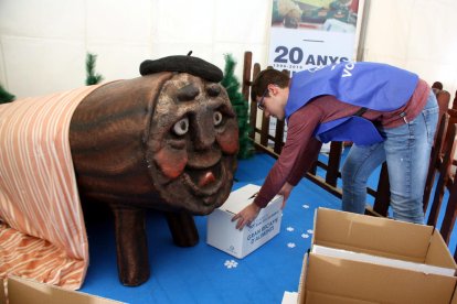 Oscar Ologaray, coordinador de la delegación ebrense del Banc dels Aliments, deposita una caja al lado del Tió Solidari.