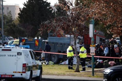 Las fuerzas de seguridad y los servicios médicos trabajan al lado del camión.