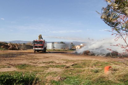 Los Bombers apagando el fuego de restos vegetales.