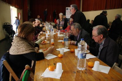 Una mesa del DiNadal con varias personas comiendo arroz blanco con tomate.