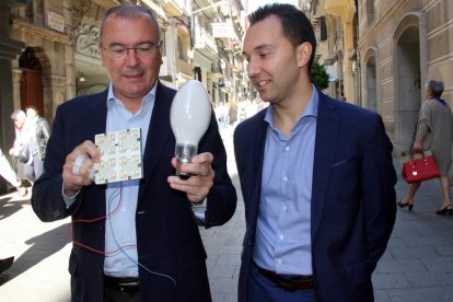 Pla mig de l'alcalde de Reus, Carles Pellicer, i del regidor de Medi Ambient, Daniel Rubio, mostrant la bombeta que se substituirà per llum led, al carrer de Llovera de Reus, un dels carrers que renovarà enllumenat, l'11 d'octubre del 2016