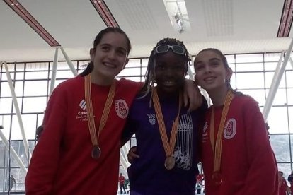 L. Marimón, en el centro, con la medalla de oro conseguida en el triple salto infantil.