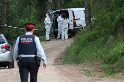 Plano general de la policía científica equipándose para acceder en el lugar donde se ha encontrado un cuerpo calcinado al lado del Pantano de Foix. En primer plano, un agente de los Mossos D'Esquadra. Imagen del 5 de mayo de 2017