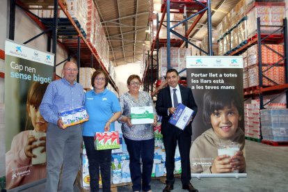 Antoni Garcia, del Banc d'Aliments; Anna Miret, dels voluntaris de 'la Caixa'; Mª Luz San Miguel, representant de l'entitat benèfica; i Jordi Creus, director d'una oficina de CaixaBank, a la seu de l'entitat a Reus, el 6 de juny del 2017