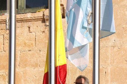 Pla obert de l'alcalde de Torredembarra, Eduard Rovira, lligant la bandera espanyola al pal.