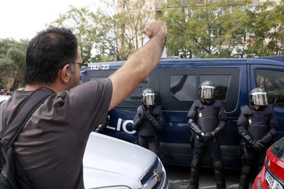 Un vecino de Sant Salvador exhibiendo una papeleta a los agentes desplegados ante|delante de el instituto de este barrio de Tarragona, el 1 de octubre del 2017