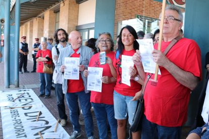 Representants de Trens Dignes amb els bitllets d'Euromed de Tarragona i Castelló, utilitzats per fer el viatge reivindicatiu des de l'estació de l'Aldea, esperant a l'andana amb la pancarta de la plataforma. Imatge del 7 de juny de 2017 (horitzontal)