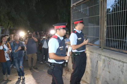 Dos agentes de los Mossos que miran el recinto del instituto Antoni Martí i Franquès de Tarragona.