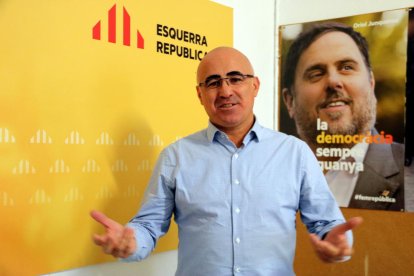 El cap de llista d'ERC per Tarragona, Òscar Peris, davant un cartell de campanya amb Oriol Junqueras.