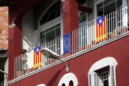 Banderes estelades en un balcó, al costat d'una bandera europea.