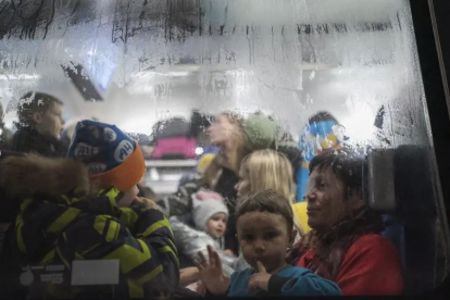 Un nen mira per la finestra d'un vagó de tren a l'estació de Lviv.