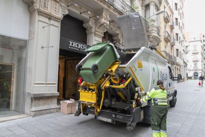 Imatge d'arxiu d'un camió i una treballadora realitzant les tasques de neteja al centre de Reus.