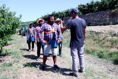 Cola de trabajadores de campo de Cerima Cherries esperando para fichar antes de empezar a coger cerezas.