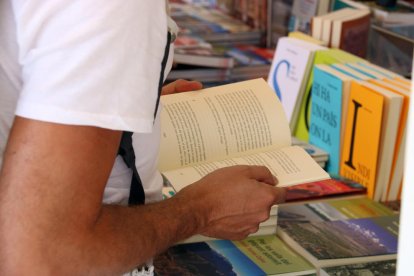 Una persona fulleja un llibre durant la darrera edició de la Setmana del Llibre en Català.