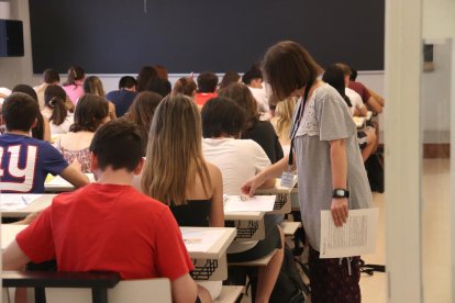 Una membre del tribunal de les PAU comprova les dades d'una estudiant.