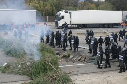 Mossos d'esquadra a l'AP-7 davant d'una barricada d'arbres.