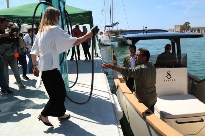 Una responsable de Aqua Marylin Marilly alcanza el cargador en el barco eléctrico de X Shore.