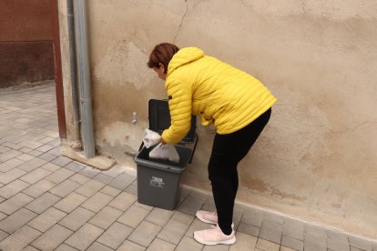 Imatge d'una veïna de Castellvell del Camp llençant la brossa al cubell.