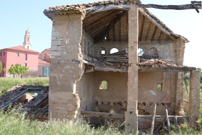 Edificio del granero medieval del antiguo convento de Carme de Valls, en estado ruinoso y rodeado de hierba.