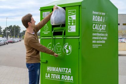 UN ciutadaà depositant roba utilitzada en un contenidor d'Humana.