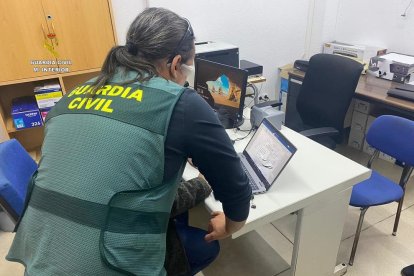 Un dels agents de la Guàrdia Civil analitzant un dels portàtils intevinguts.