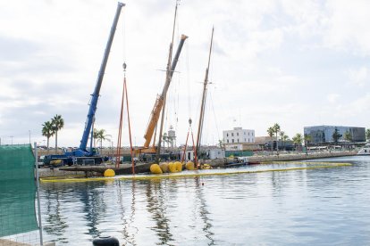 Dos grandes grúas empiezan a sacar del agua el Eleonora E hundido en la Marina Port Tarraco