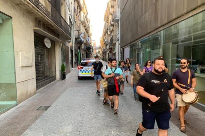 Els grup de grallers amb un cotxe de la Guàrdia Urbana darrere.